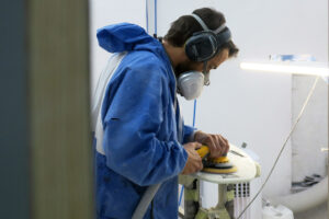 Appletree crew member Joao sanding kiteboard in factory Appletree Surfboards