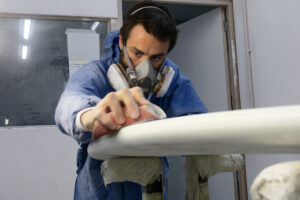 Appletree crew member Joao sanding kiteboard in factory Appletree Surfboards